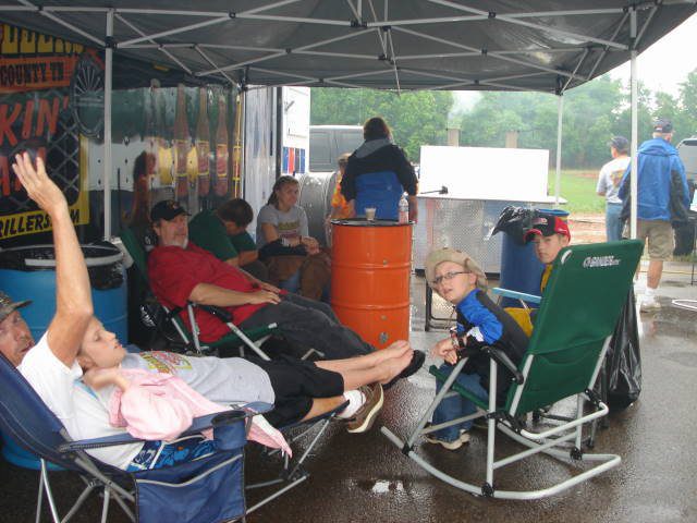 Jr Grillers team members waiting on food to cook during a competition in the rain